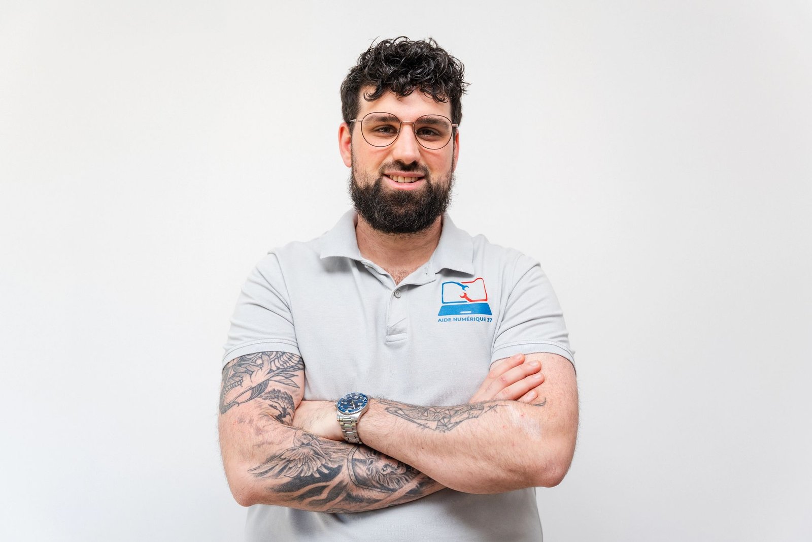 Pierrick Le Penru, fondateur d'Aide Numérique 37, en polo brodé, bras croisés, souriant