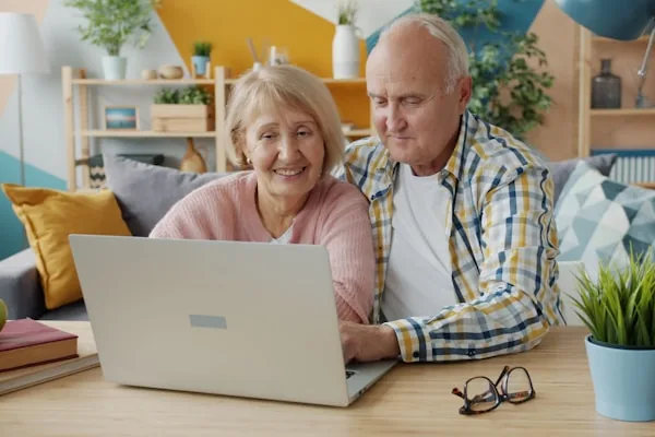 Couple de seniors heureux utilisant un ordinateur